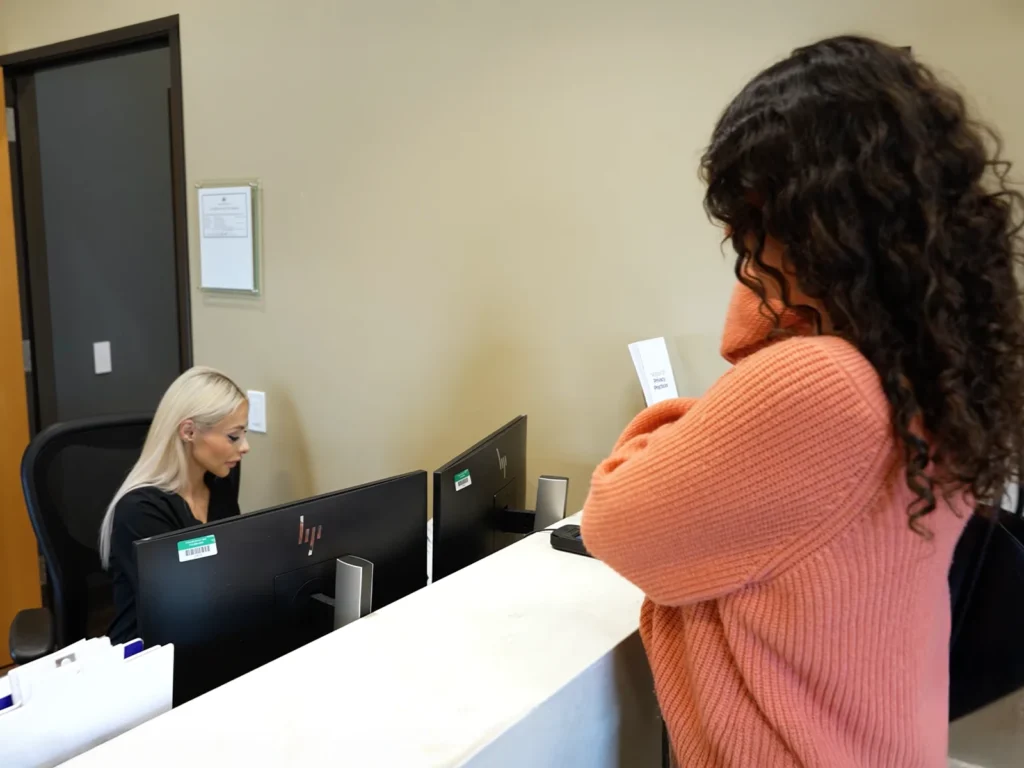 Front desk staff assisting patient during check-in